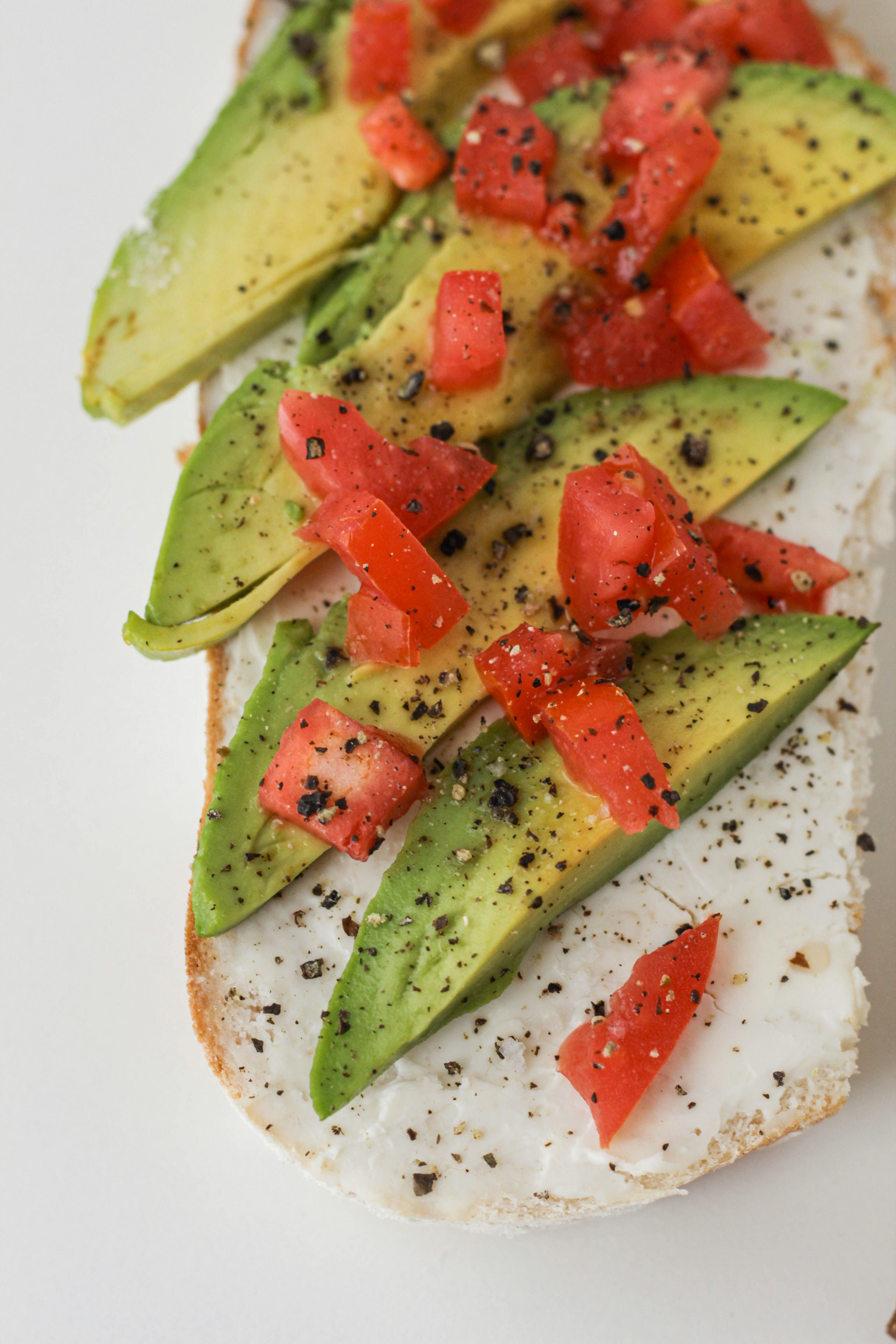 sliced tomato and green vegetable on white ceramic plate